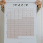 Woman holding the summer planning page from the 2027 family wall calendar
