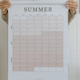 Woman holding the summer planning page from the 2027 family wall calendar