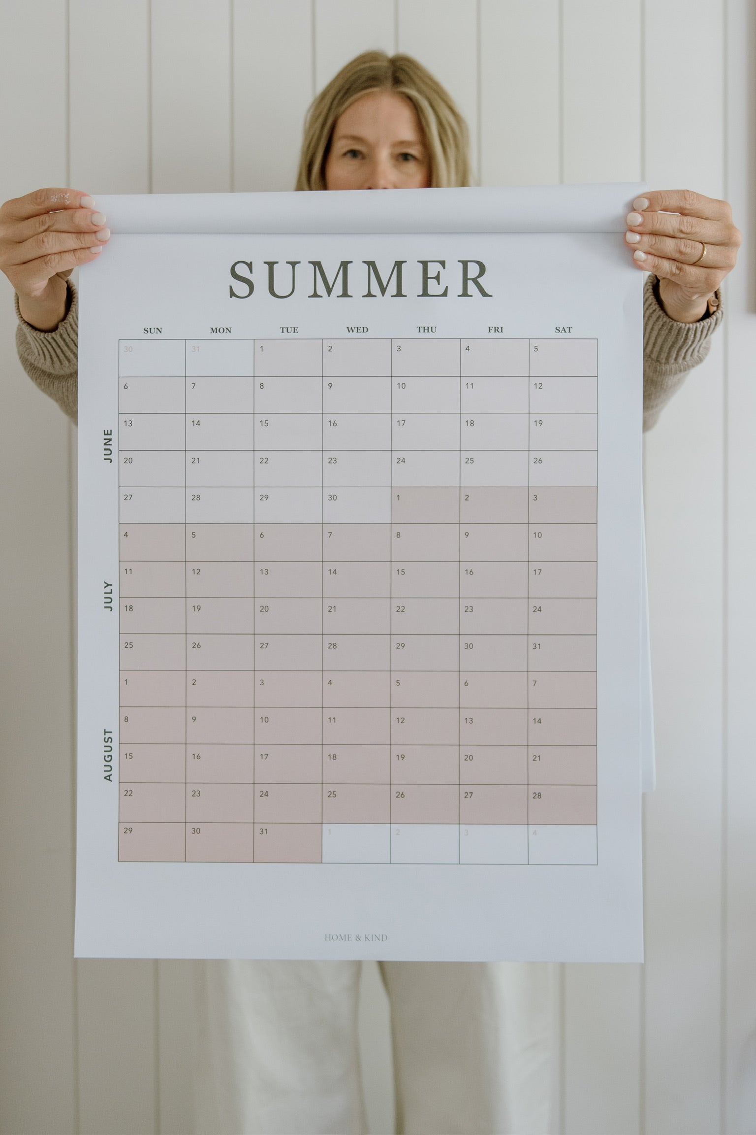 Woman holding the summer planning page from the 2027 family wall calendar