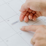 Hands placing a sticker on a day in the large wall calendar