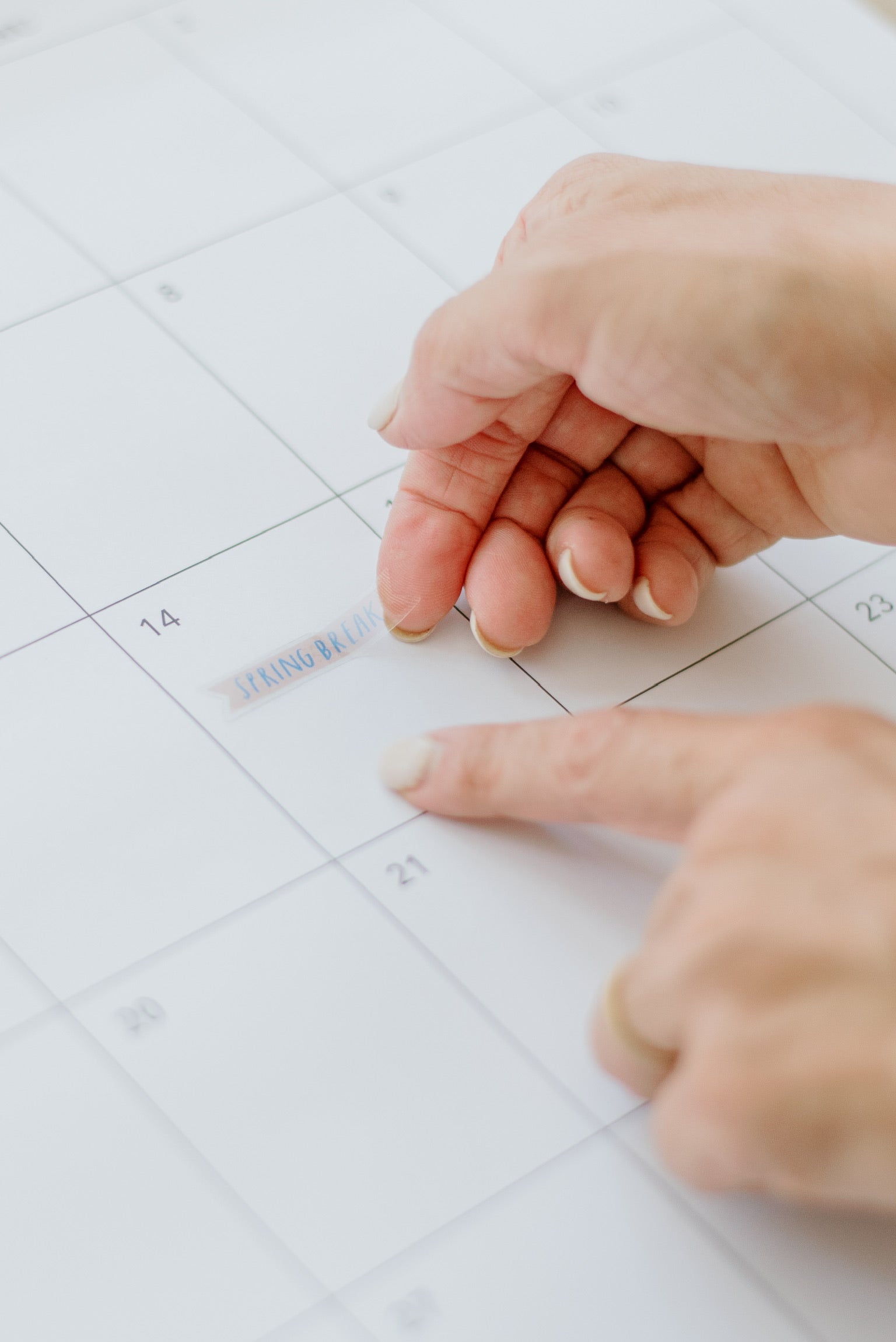 Hands placing a sticker on a day in the large wall calendar