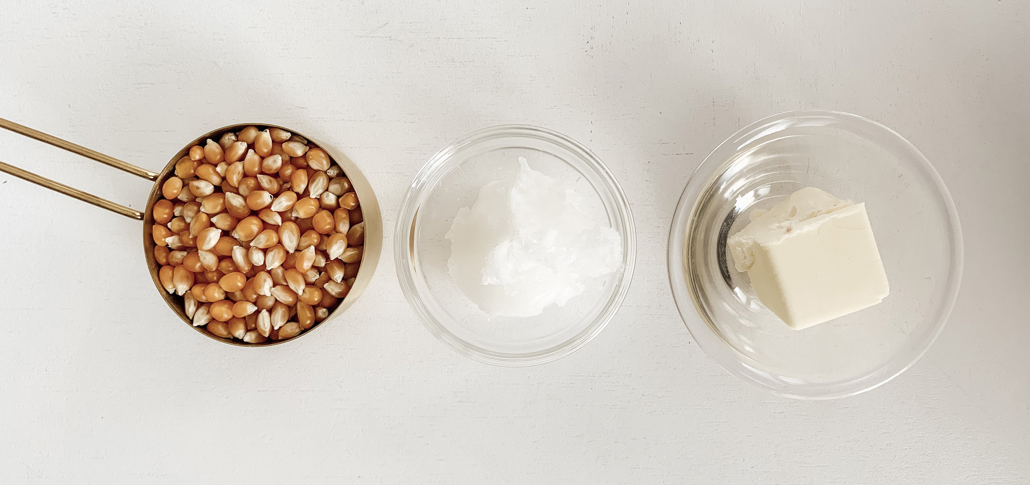 Popcorn kernels, coconut oil, butter in small glass bowls