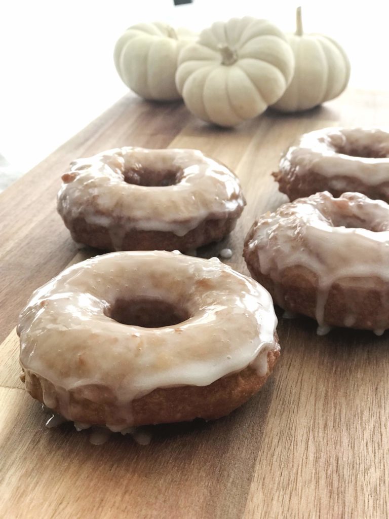 glazed pumpkin donuts with small white pumpkins