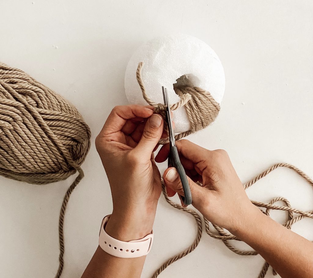 tie another piece of yarn and cut off the excess for your DIY yarn pumpkin
