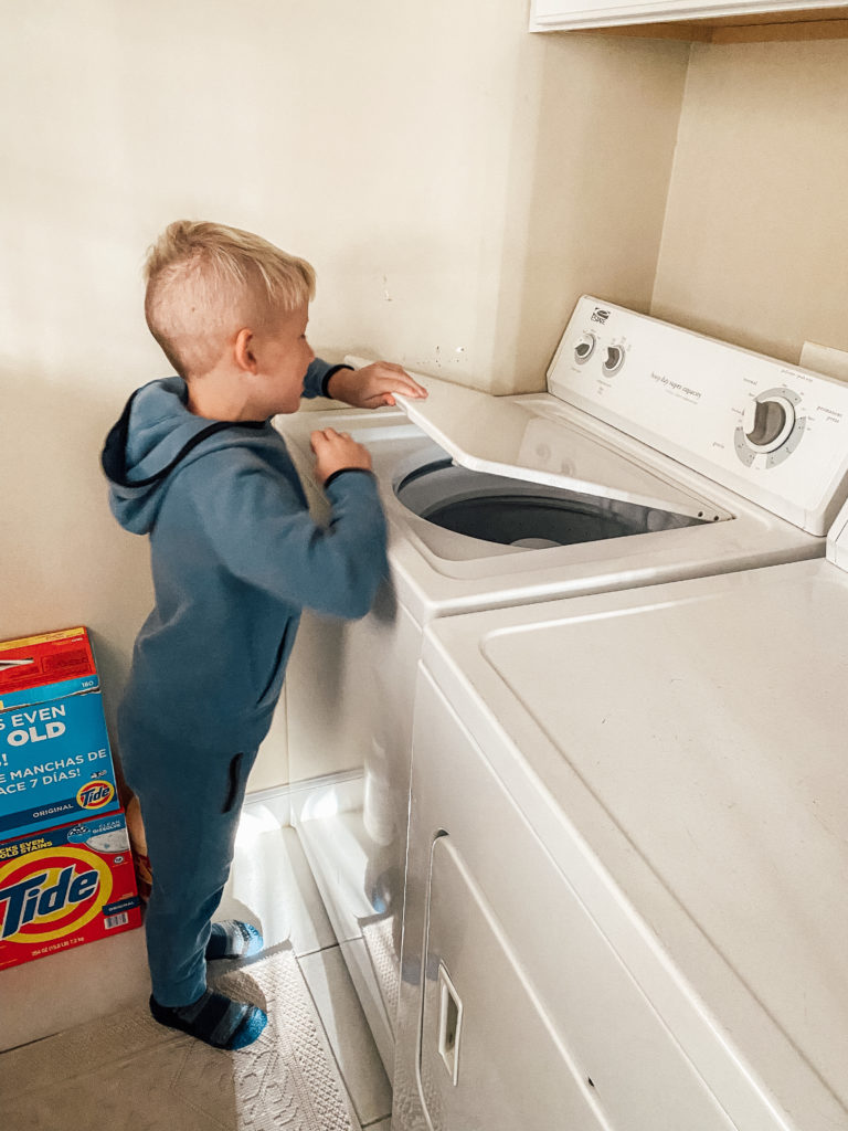 My son putting laundry in the washer
