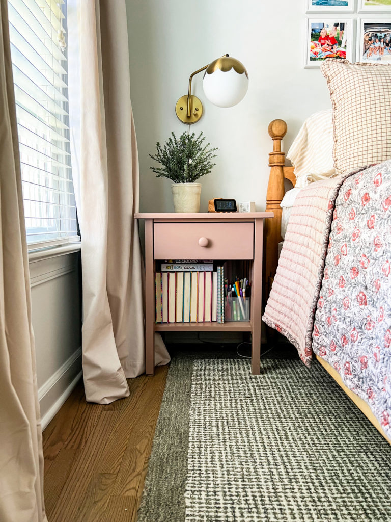 Kate's nightstand, with a sconce above it