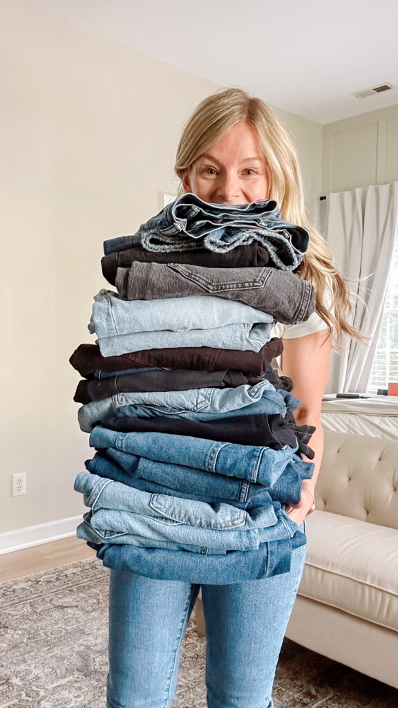 Brittney holding a stack of jeans